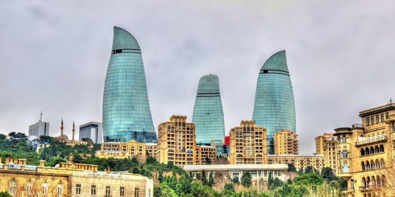 View of Baku with multiple skyscrapers behind old stone buildings