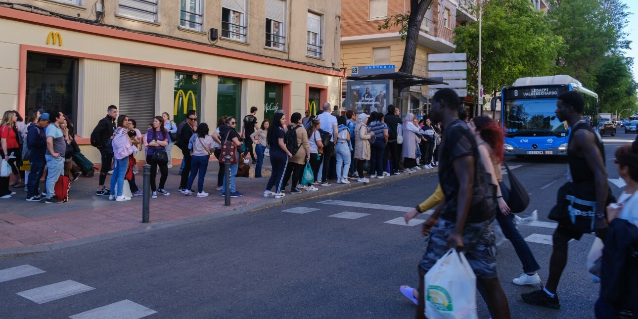 While people cross the road, others queue for a bus outside a McDonald's restaurant.