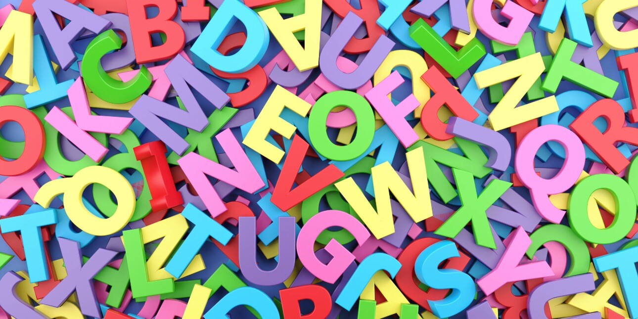 A bird's eye view of a pile of magnetic letters in different pastel colours
