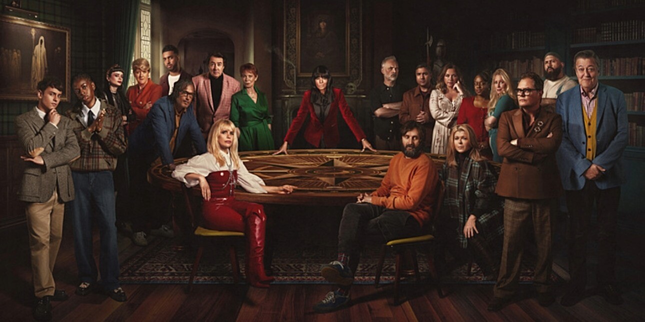A BBC publicity photo of Claudia Winkleman and the cast of Celebrity Traitors in a darkened room around a table