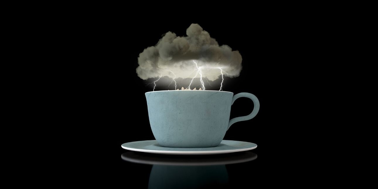 A 3D render a grey storm cloud hovering over a turbulent cup of tea in a blue cup with lightning striking. The background is black.
