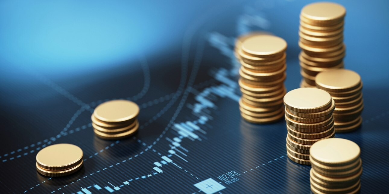 Seven stacks of coins of different heights sat on a blue financial graph.