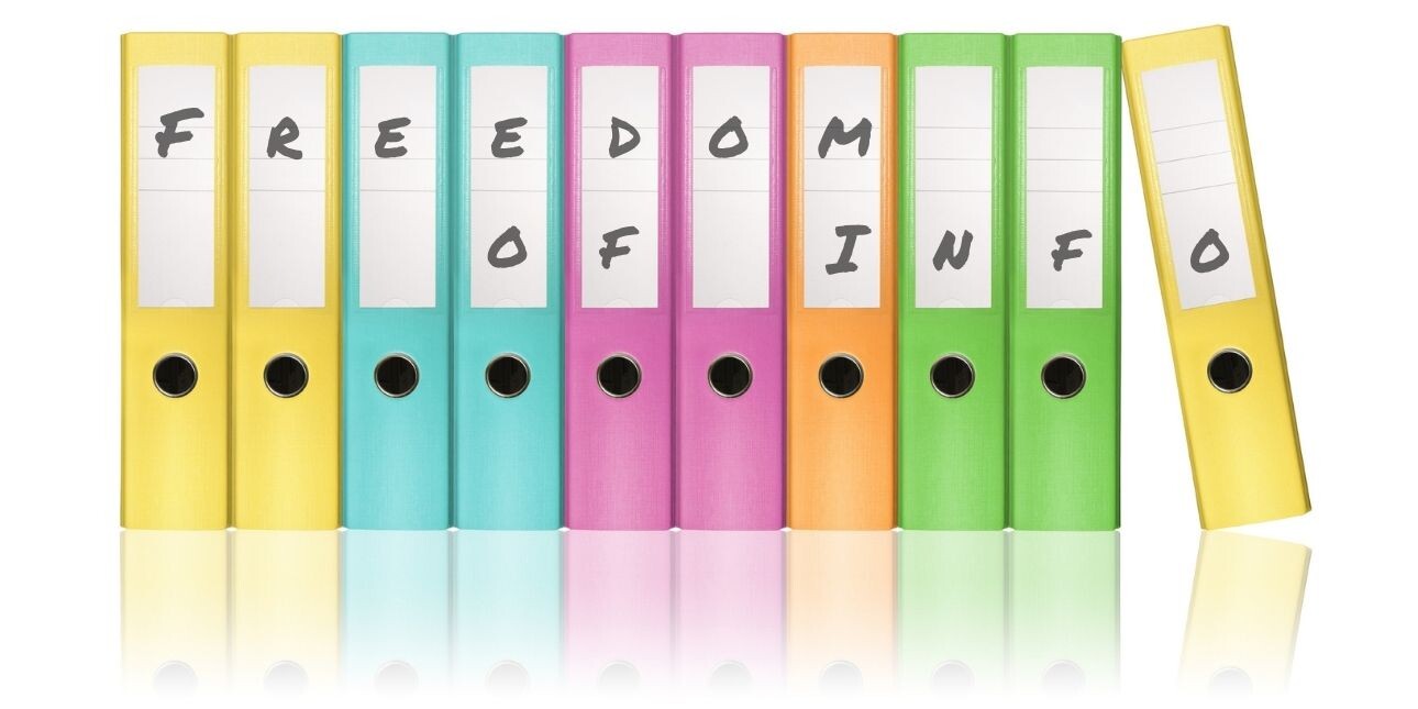 A row of ten multi-coloured ring-binder folders with the words freedom of info written across them.