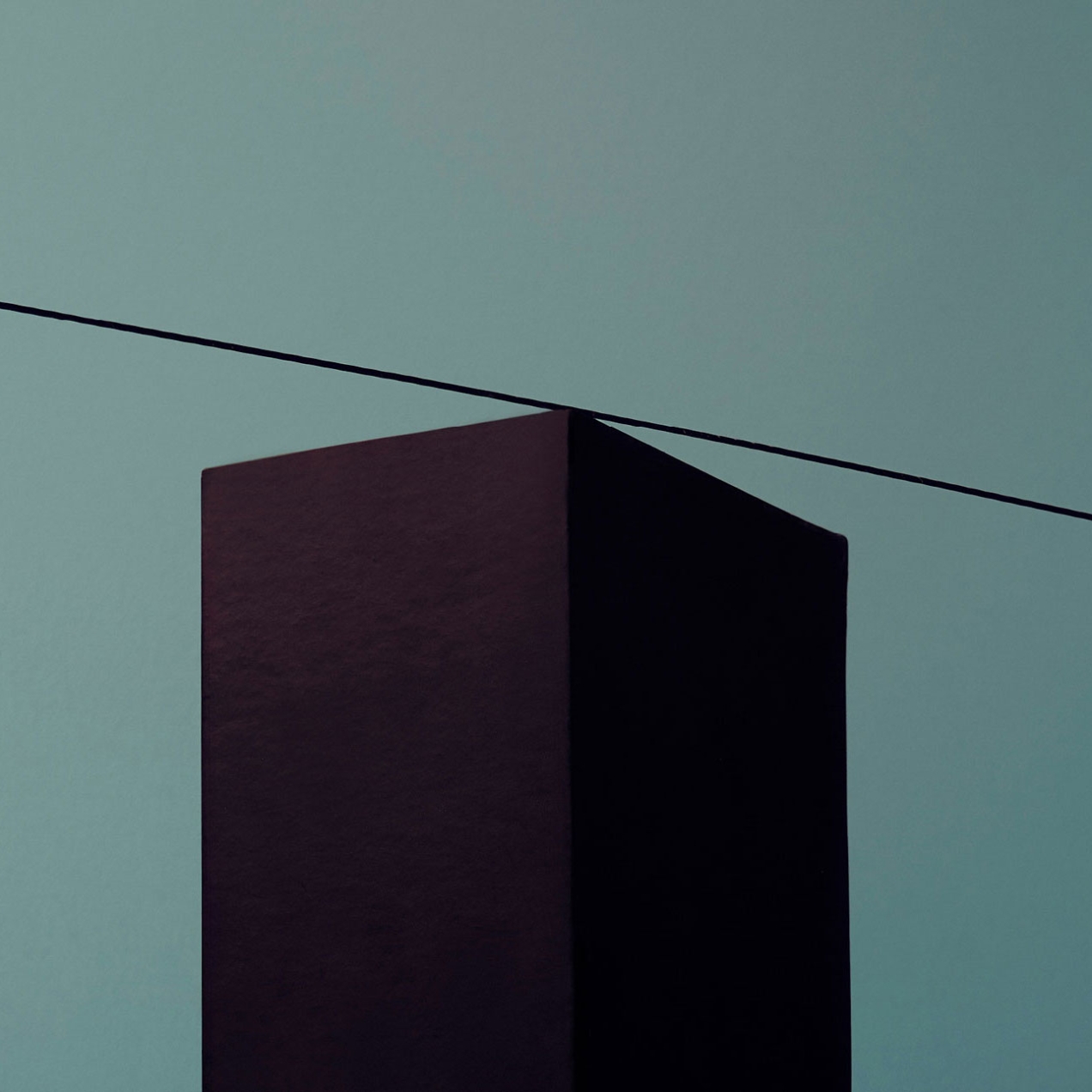 A rod with two yellow spheres attached to it is balancing on the edge of a black brick – getting the right balance.