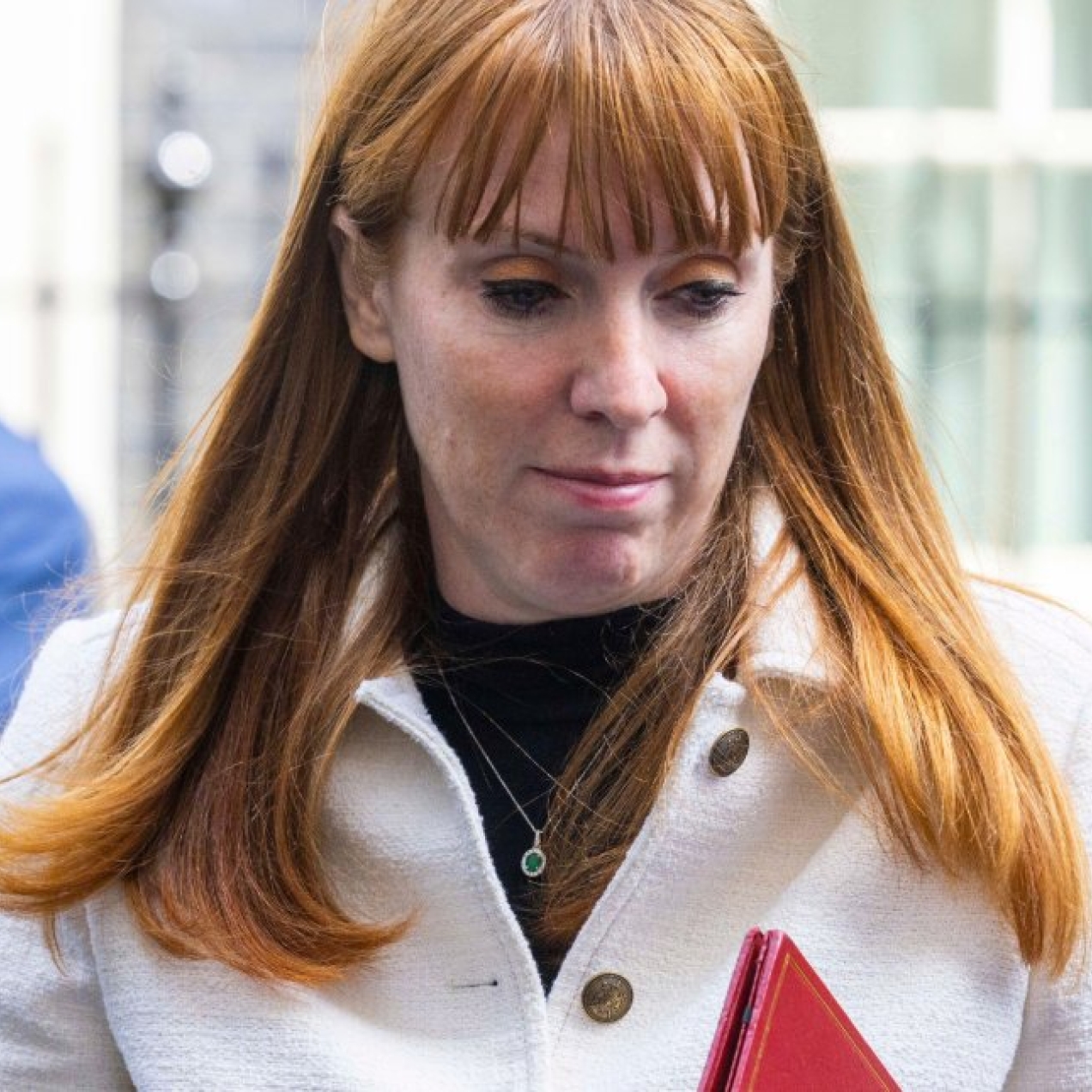 Angela Rayner with her eyes looking downwards while carrying a red ministerial folder.