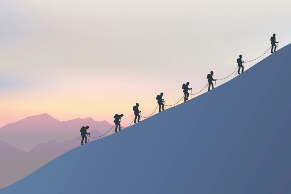 Silhouettes of eight mountain climbers linked by a rope making their way up a 45-degree angled mountain slope