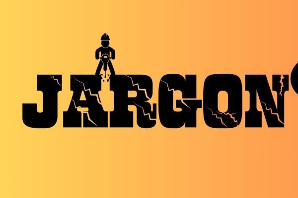 On a yellow-orange background is the word jargon in cracked black type. Balancing at the top of the letters A and R is the silhouette of a construction worker with a jackhammer and to the right is a wrecking ball and chain