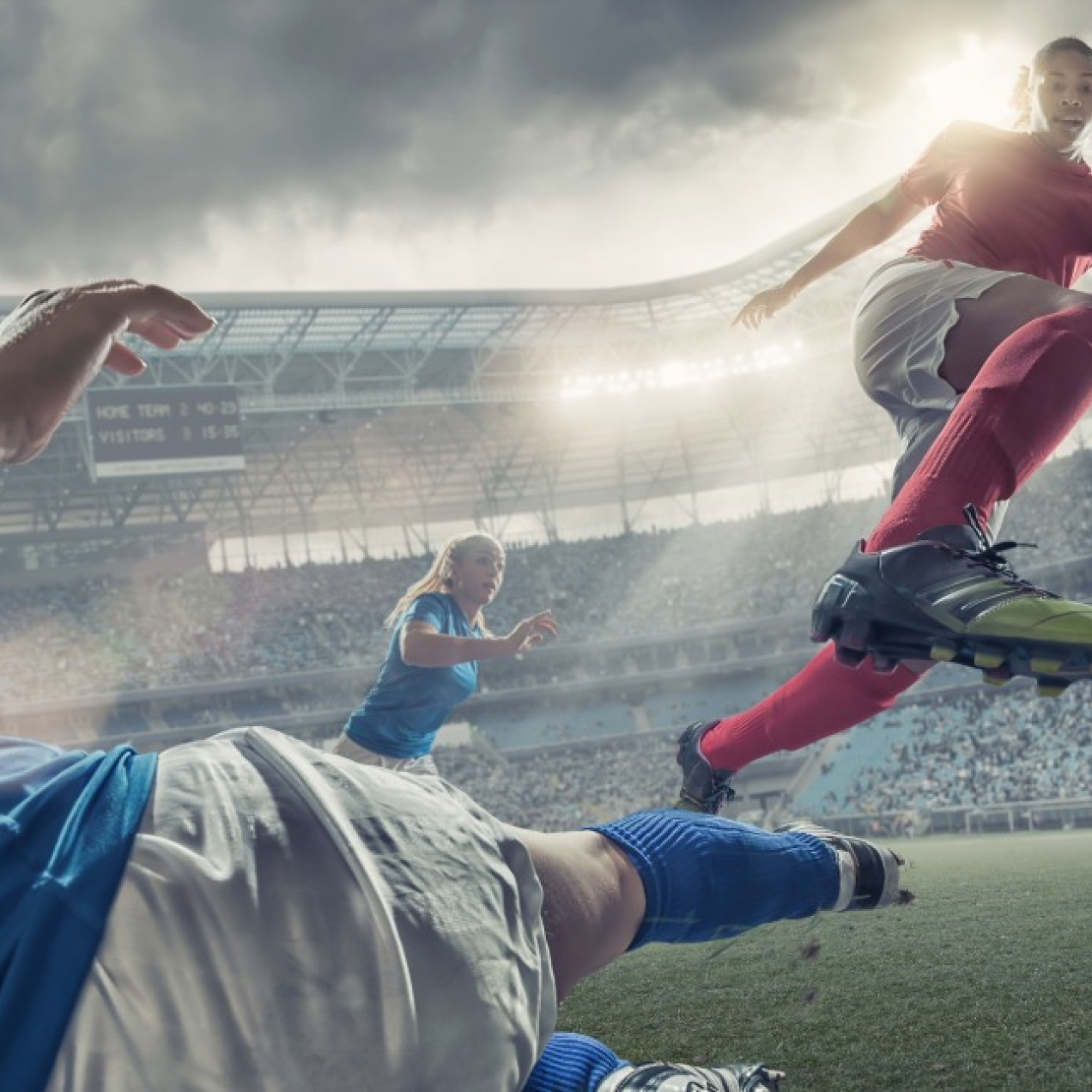 A computer generated illustration of a female football player in mid-air kicking a football in a stadium. Underneath her are the legs of an opposing defender trying to tackle.