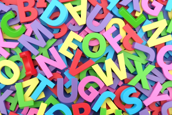 A bird's eye view of a pile of magnetic letters in different pastel colours