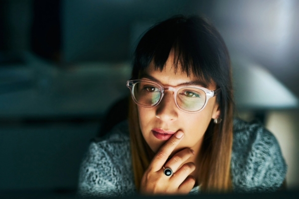 High angle shot of a businesswoman looking thoughtful while working on her computer late at night in the office