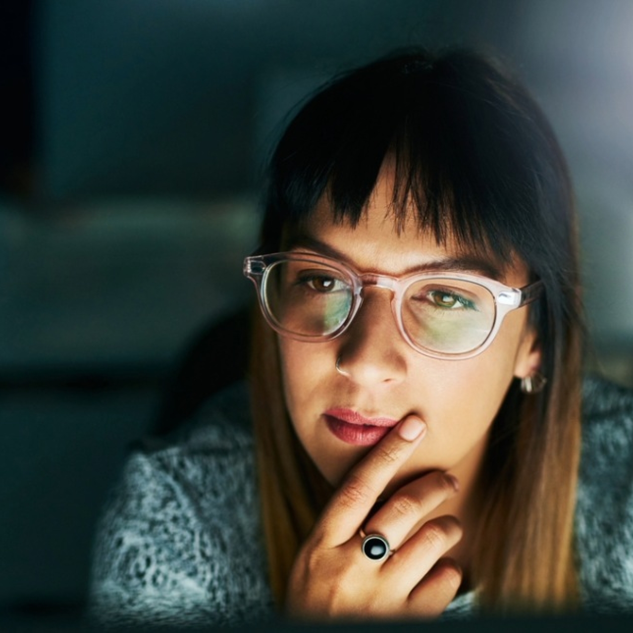 High angle shot of a businesswoman looking thoughtful while working on her computer late at night in the office