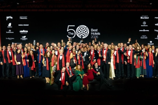 A crowd of people stood celebrating in front a banner which reads the world's best 50 hotels.