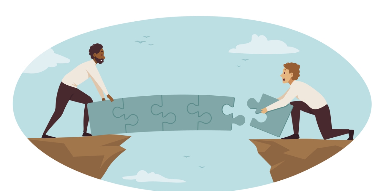 Illustration showing two men building a bridge made out of jigsaw pieces across a canyon