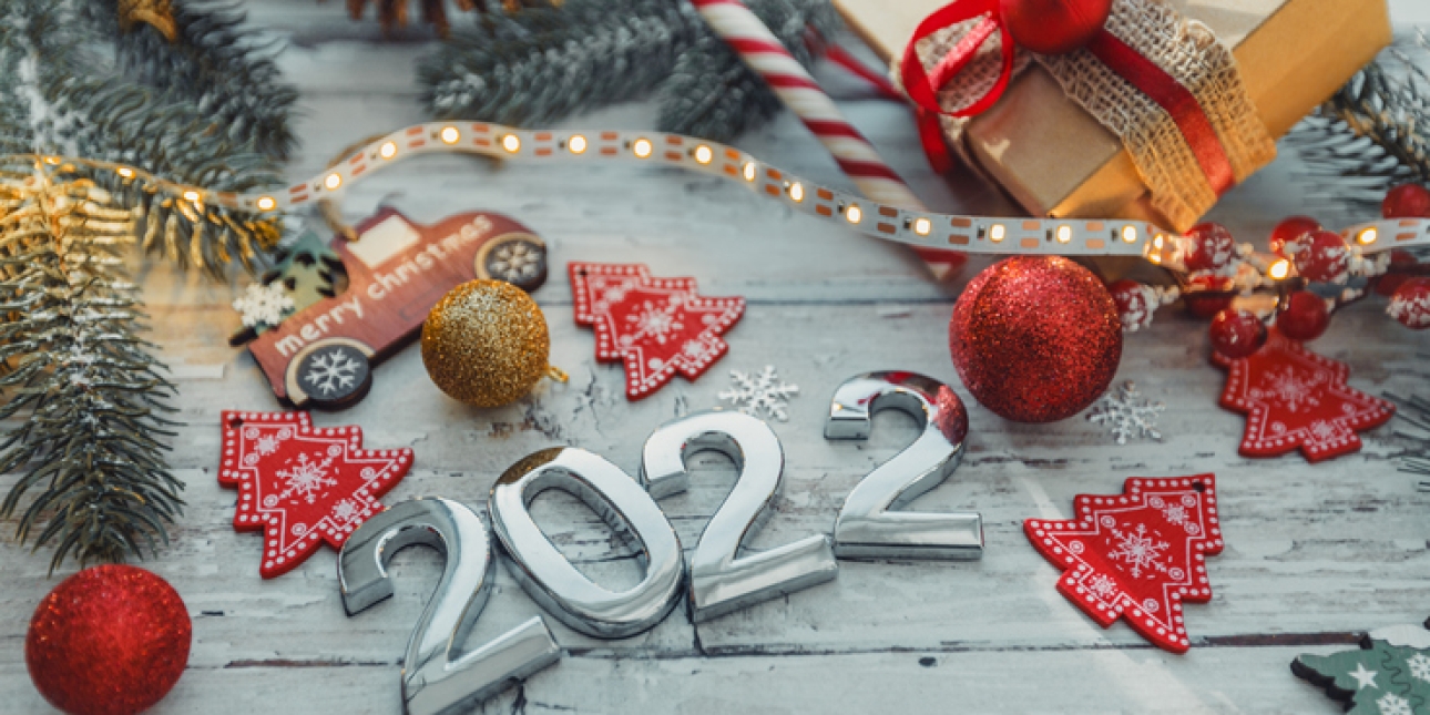 Silver numbers 2022 on a wooden background with Christmas decorations and snowflakes