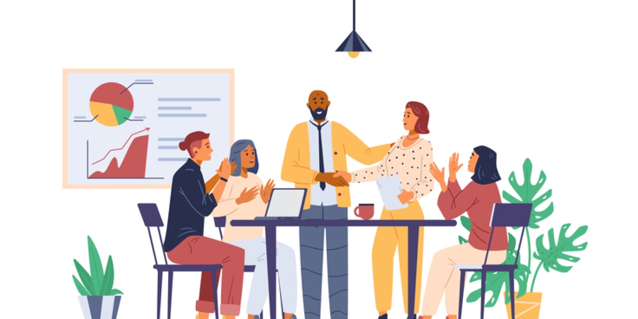 An illustration of four people in a team at a desk and welcoming a new colleague.