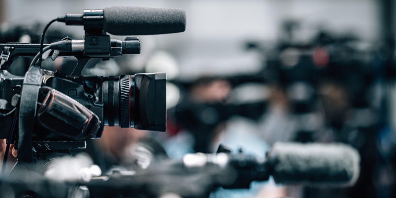 Side profile of a TV news camera against a blurred background