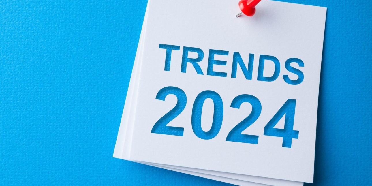 A white post-it note pinned to a blue board. The words trends 2024 are cut out of the note