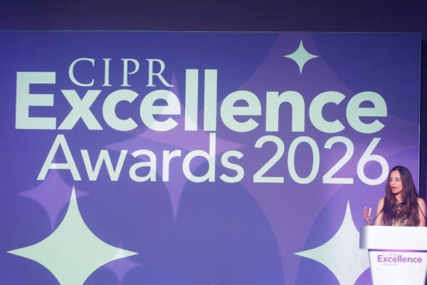 A woman (Farzana Baduel) stood behind a lectern on the right of a stage bathed in purple light. A banner reads CIPR Excellence Awards 2026.