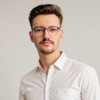 James Sharp, a white man with short brown hair, glasses and beard, glasses and wearing a white shirt