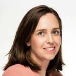 Katy Granville, a white woman smiles at the camera side on, she has shoulder length brown hair and is wearing a pink top 