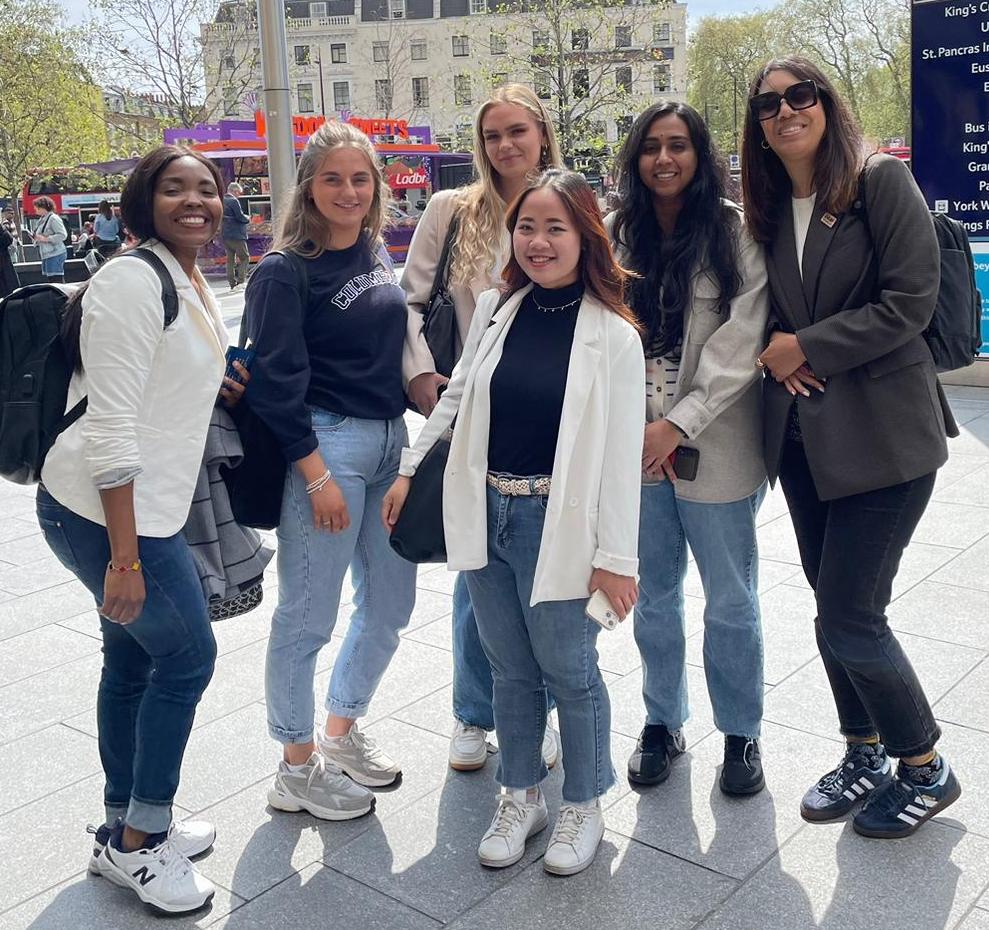 Six members of the Leeds Beckett University team pose smiling for a photo outside London's Kings Cross station