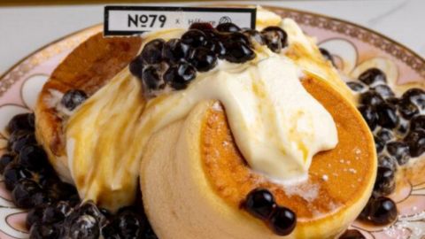 Souffle pancakes on a plate topped with blueberries and cream