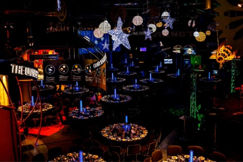 A room set with dining tables and various lights hanging from the ceiling to represent moons and stars