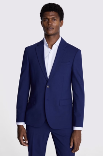 A black man with short dark hair wears a slim cut blue suit and a white shirt