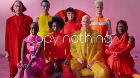 A still from the Jaguar advert showing eight people of different ages, ethnicities and genders in neon-coloured clothing against a pink background. 