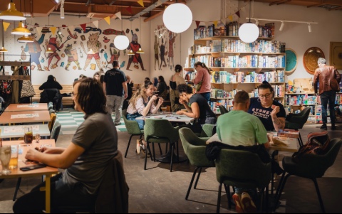A room full of tables occupied with people playing various games